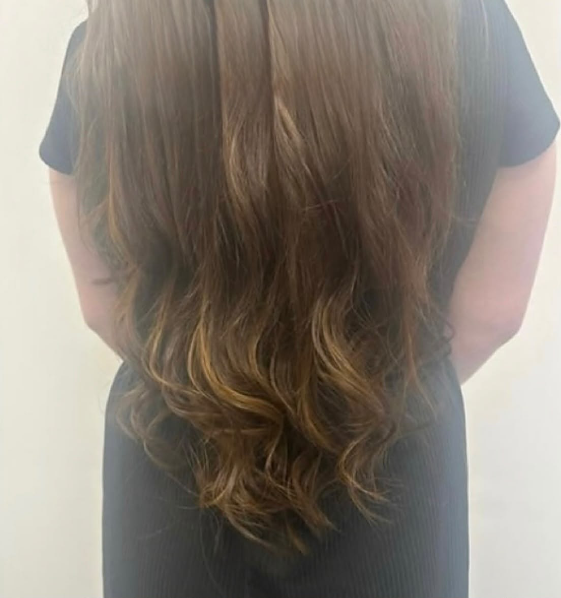 Finished brunette extensions with honey-toned ends, seen from behind